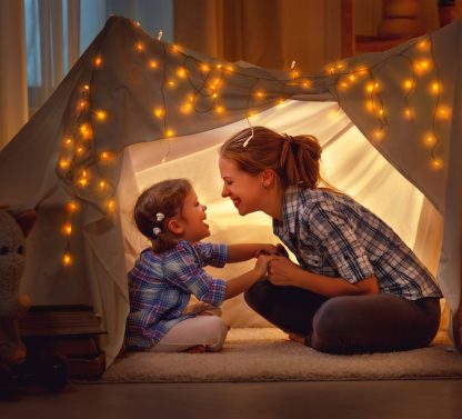 a little girl and a little girl playing in a tent.