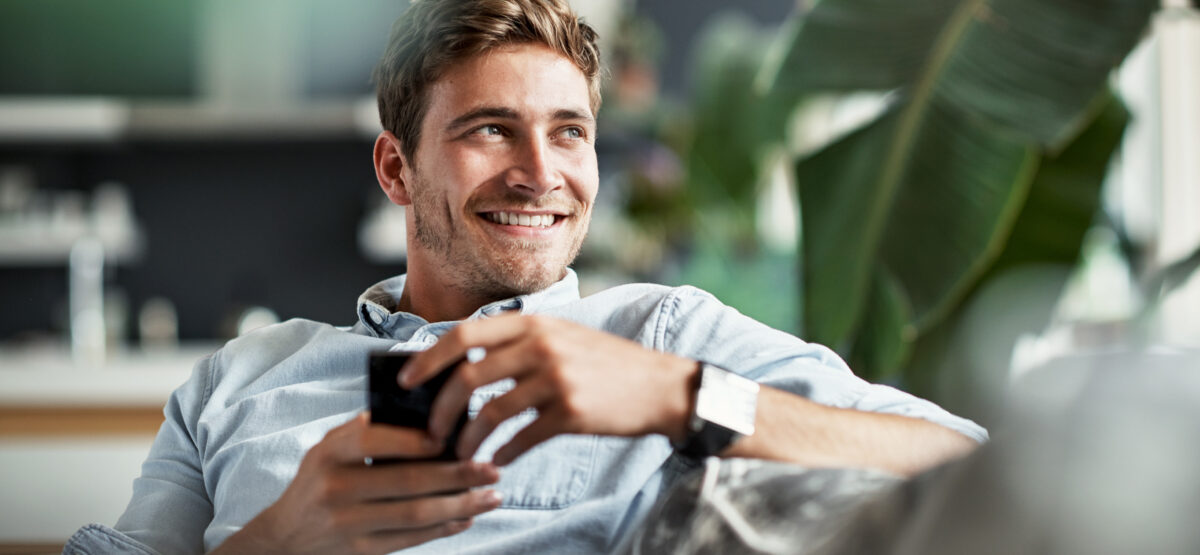 Man sitting on couch holding phone
