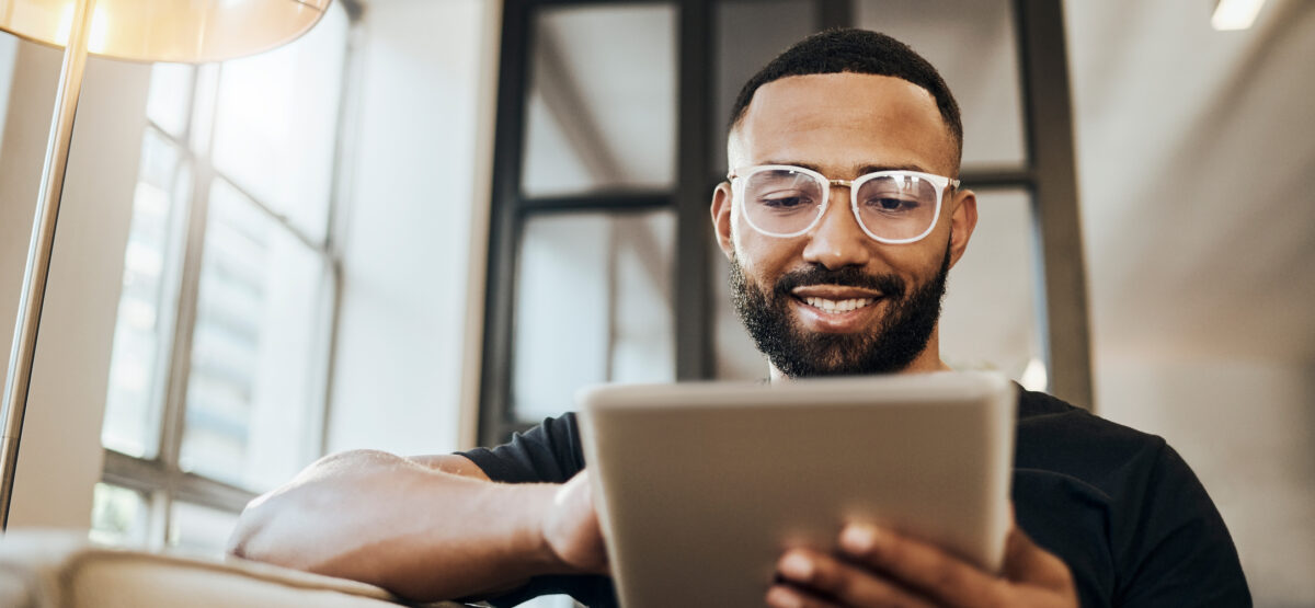 man on couch on tablet