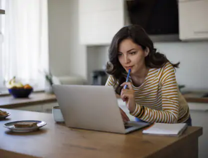 Women leaning over counter on laptop